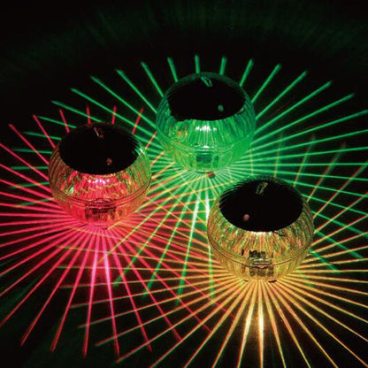 Three disco ball-like objects emitting red and green laser lights on a dark background