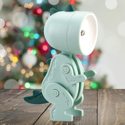 Light blue dinosaur-shaped lamp on a wooden surface with a blurred festive background