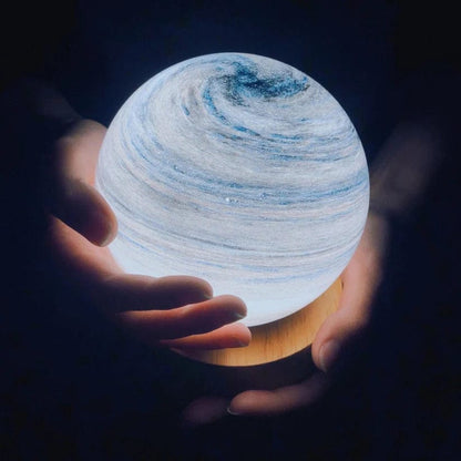Holding a spherical light source with a planetary design in a dark setting