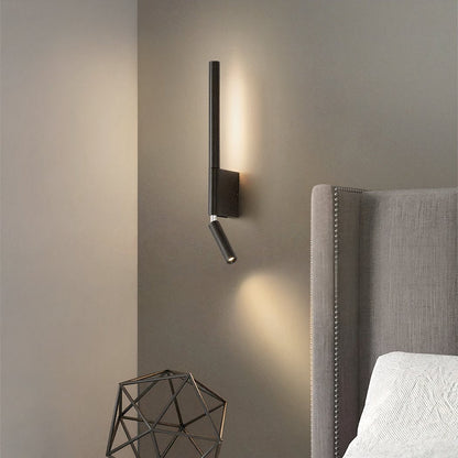 Modern wall-mounted light fixture on a neutral wall next to a upholstered headboard.